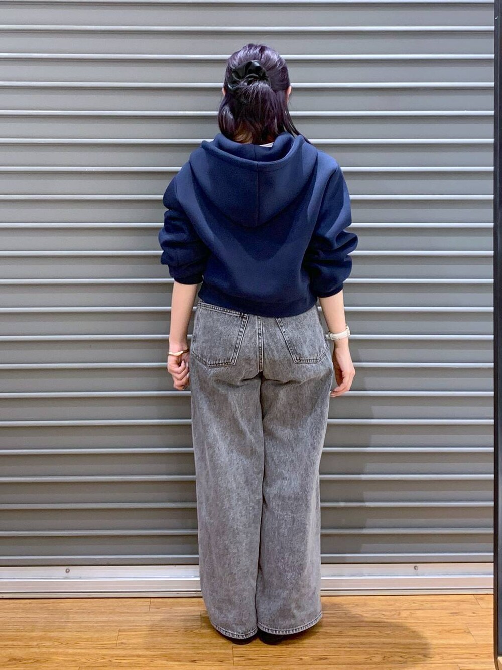 ブラック系のローファー、グレー系のデニムパンツ、ブルー系のパーカーを着用したレディースの春コーディネートの2枚目の写真