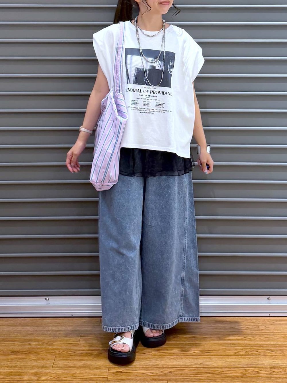 パープル系のトートバッグ、ホワイト系のサンダル、ホワイト系のTシャツ/カットソーを着用したレディースの夏コーディネートの4枚目の写真