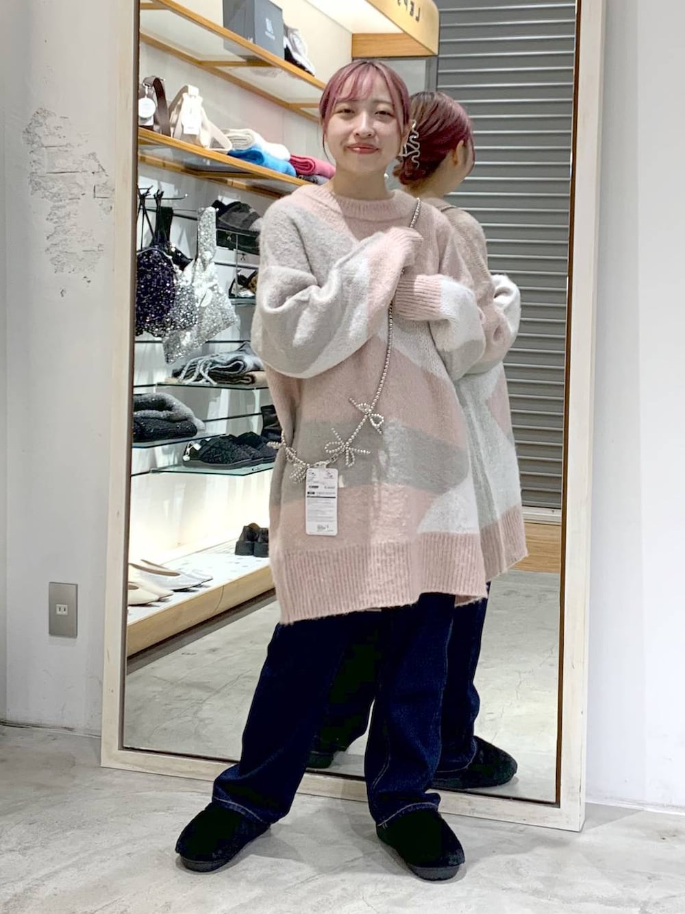 ブルー系のデニムパンツ、ブラック系のその他シューズ、ピンク系のチュニックを着用したレディースの秋コーディネートの3枚目の写真