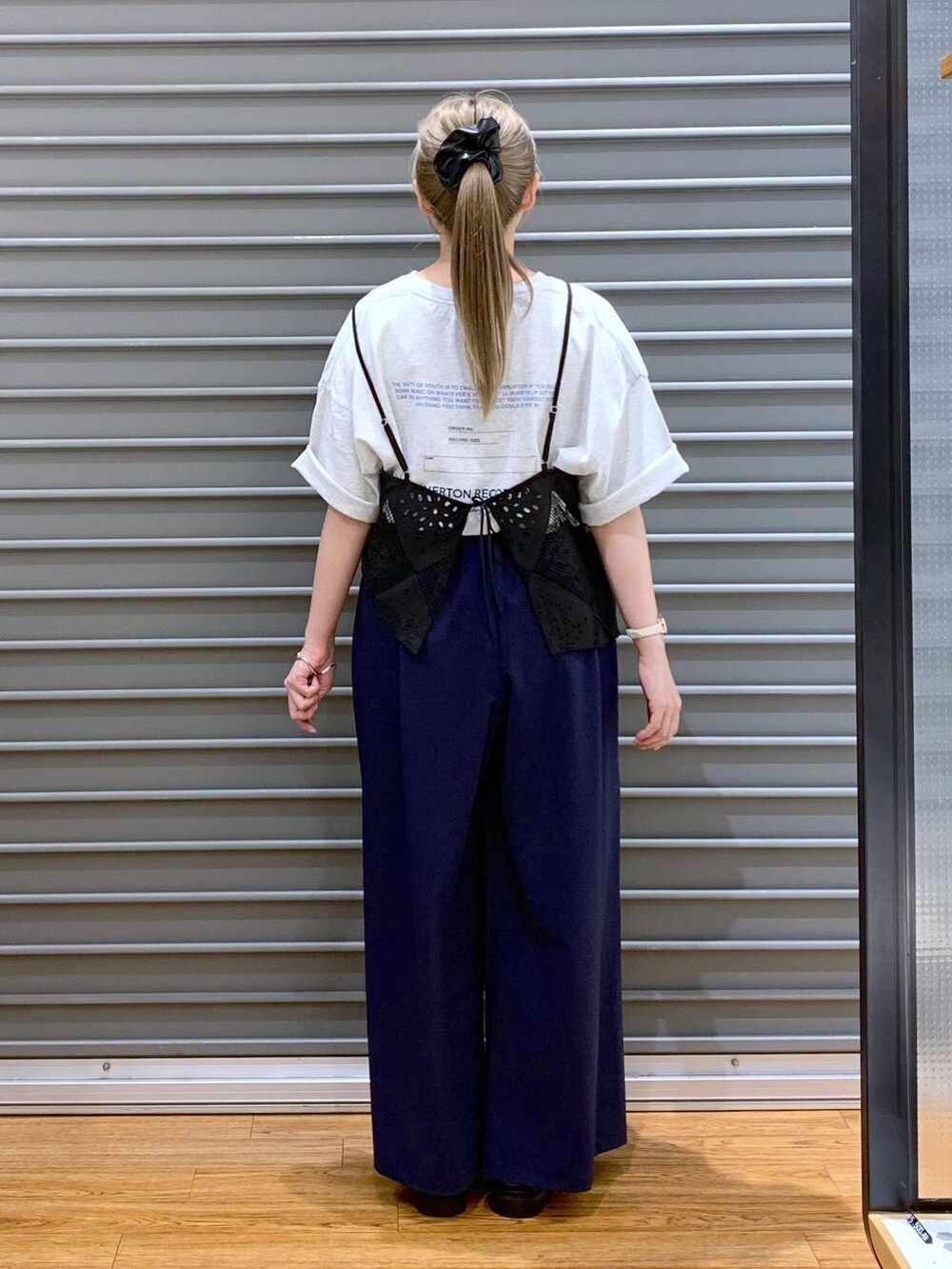 ブラック系のサンダル、ブルー系のその他パンツ、ホワイト系のショルダーバッグを着用したレディースの夏コーディネートの2枚目の写真