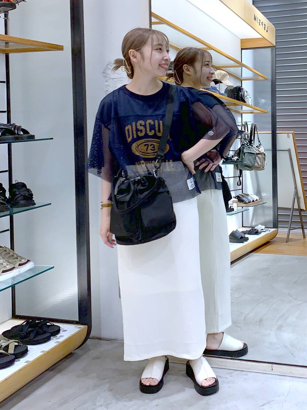 ブラック系のショルダーバッグ、ホワイト系のサンダル、ホワイト系のスカートを着用したレディースの夏コーディネートの3枚目の写真