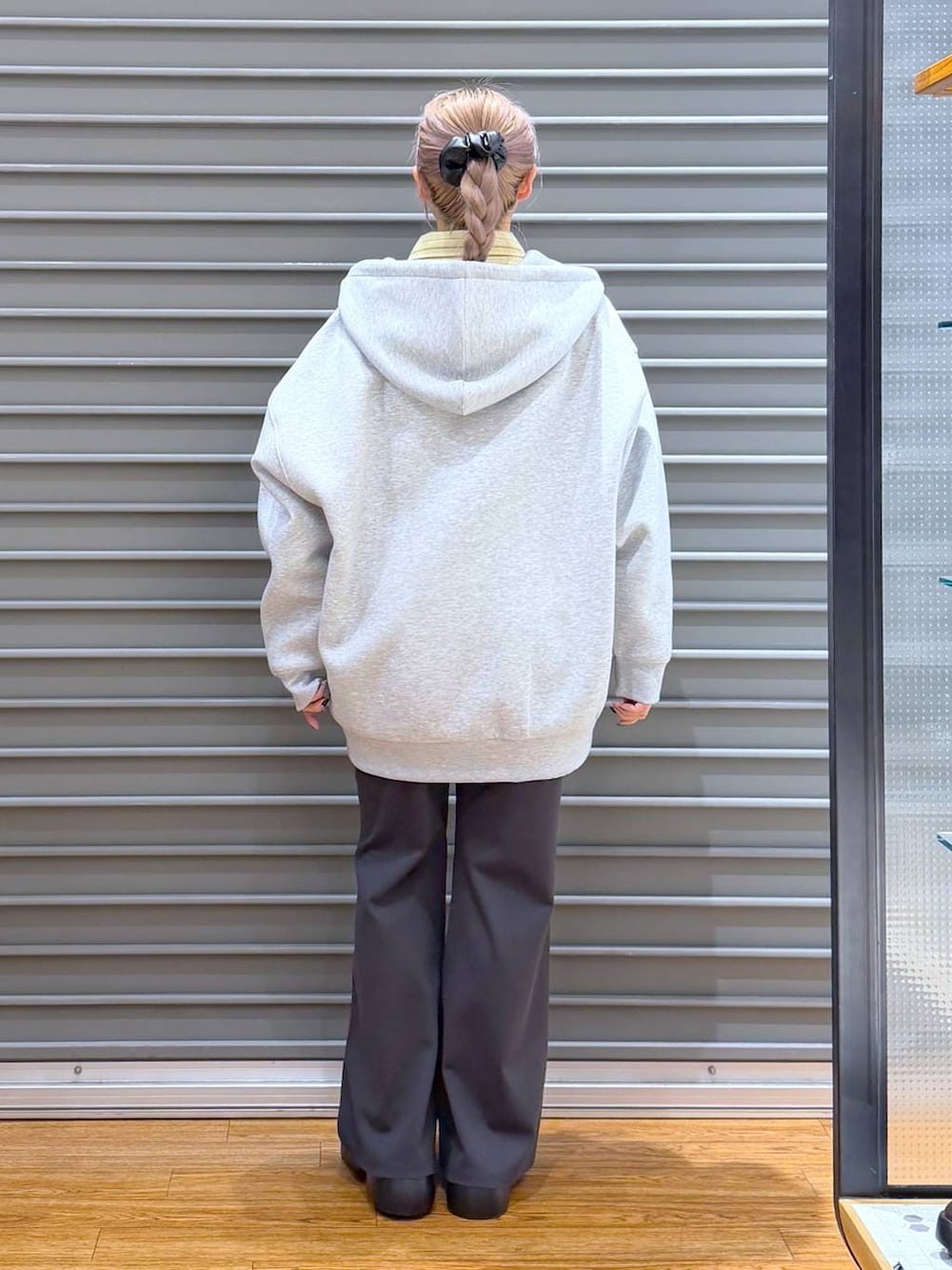 ブラック系のサンダル、ブラック系のボストンバッグ、グレー系のパーカーを着用したレディースの冬コーディネートの2枚目の写真