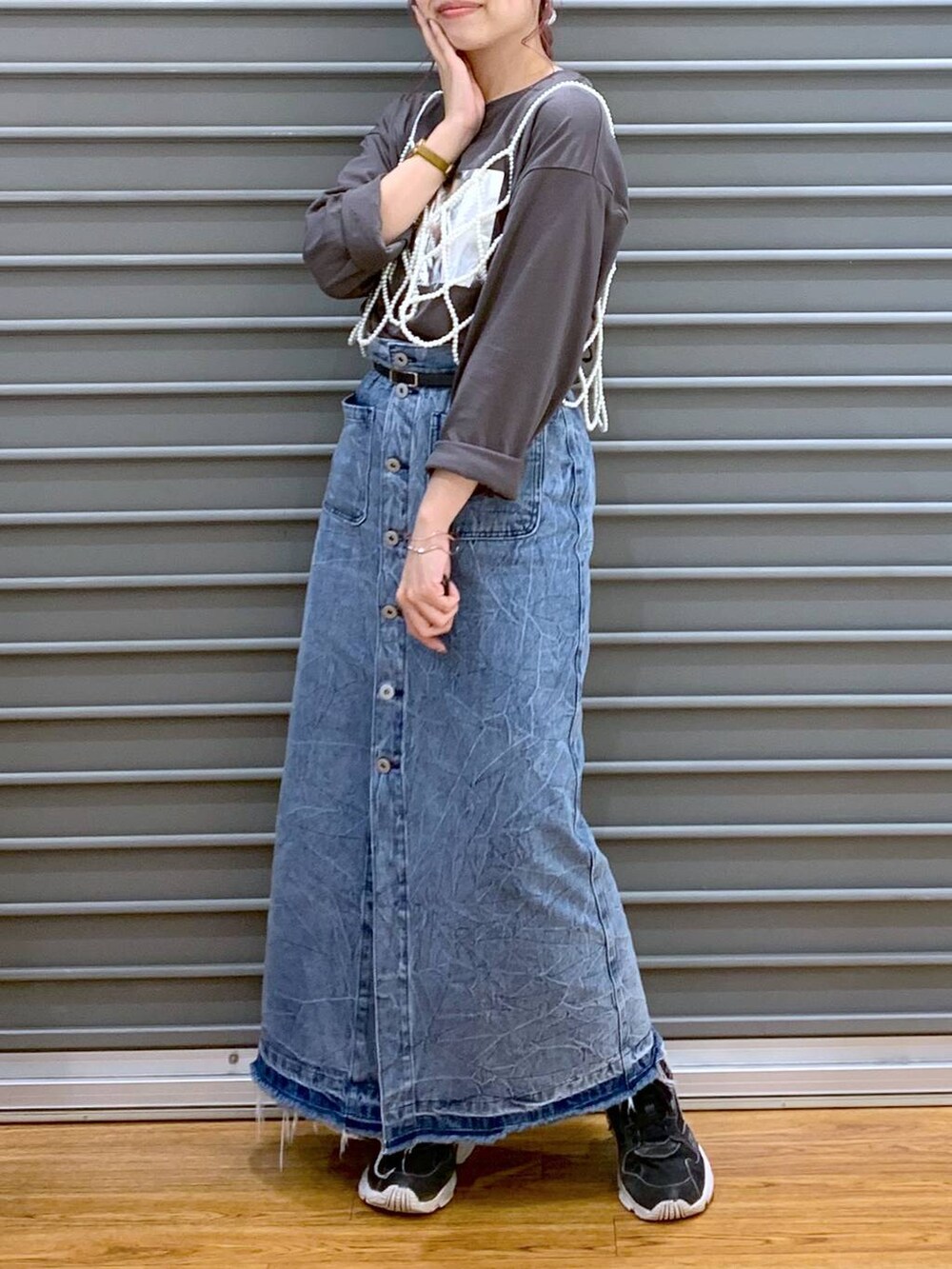 ホワイト系のベスト、ブルー系のデニムスカート、グレー系のTシャツ/カットソーを着用したレディースの秋コーディネートの4枚目の写真