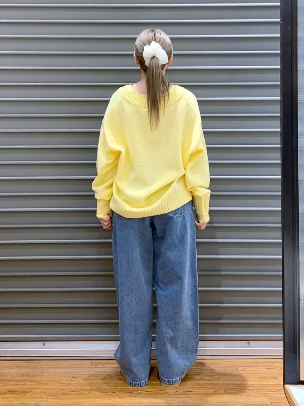 イエロー系のニット/セーター、ブラック系のブルゾン、ブラック系のトートバッグを着用したレディースの冬コーディネートの3枚目の写真