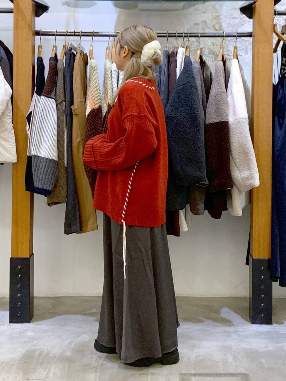 ブラック系のブーツ、ブラック系のショルダーバッグ、レッド系のカーディガン/ボレロを着用したレディースの冬コーディネートの3枚目の写真