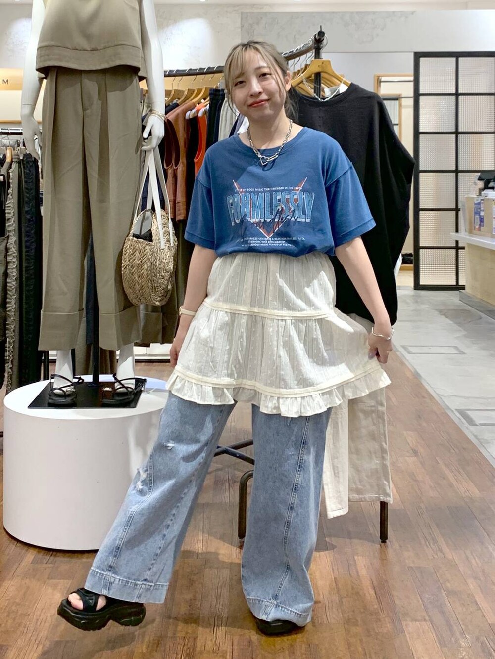 ブルー系のデニムパンツ、ブラック系のサンダル、ブラック系のショルダーバッグを着用したレディースの夏コーディネートの5枚目の写真