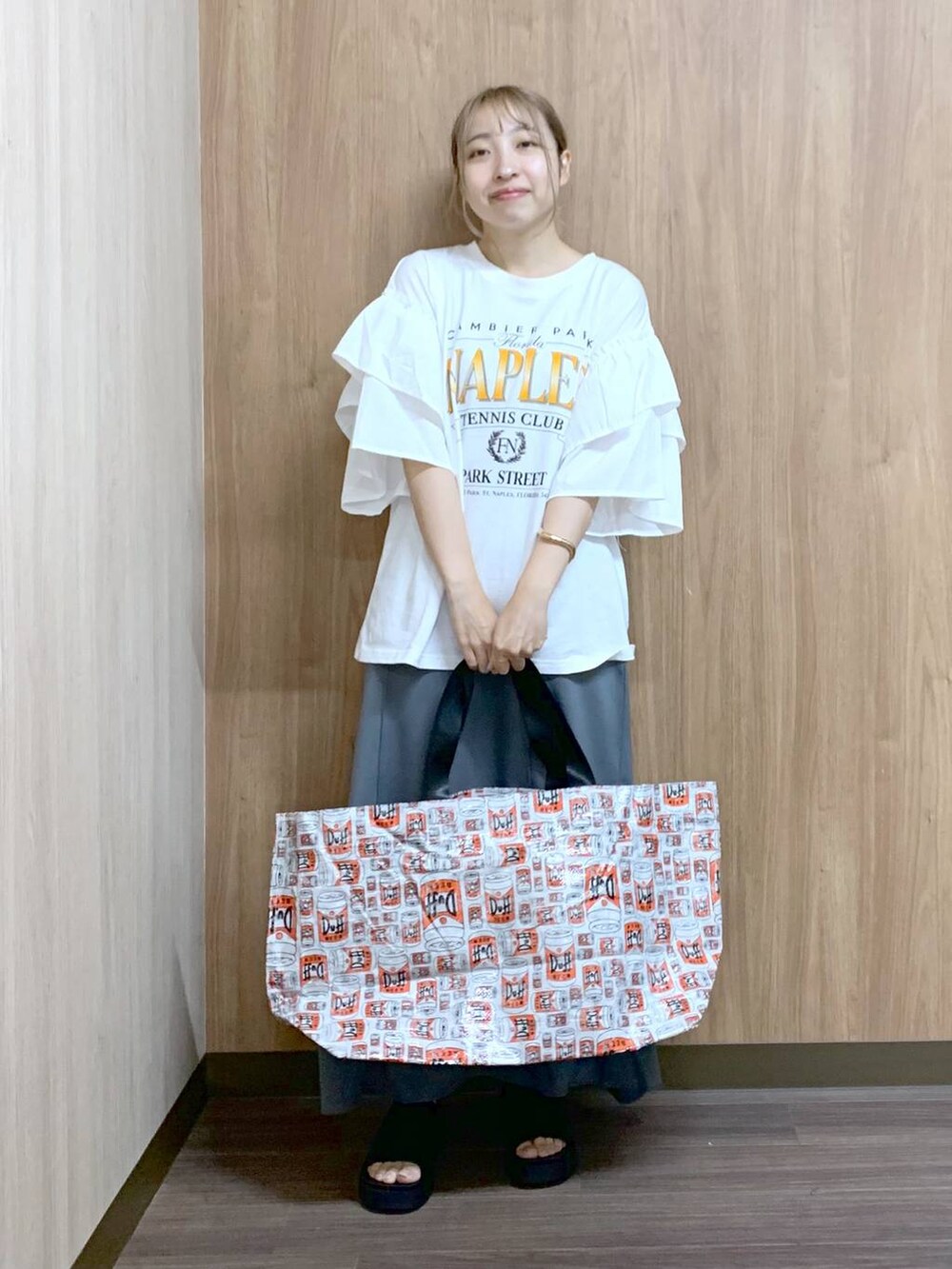 グレー系のスカート、グレー系のトートバッグ、ブラック系のサンダルを着用したレディースの夏コーディネートの4枚目の写真