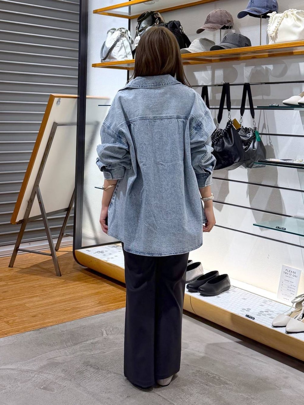 ブラック系のボストンバッグ、シルバー系のパンプス、ブルー系のシャツ/ブラウスを着用したレディースの冬コーディネートの2枚目の写真