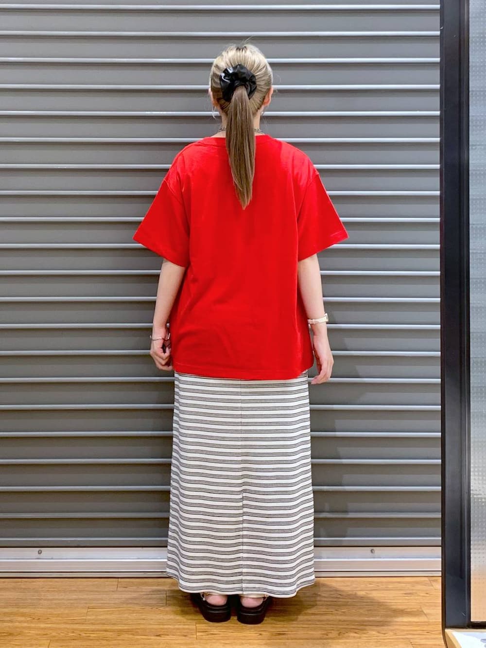 ブラック系のスカート、ホワイト系のサンダル、ホワイト系のショルダーバッグを着用したレディースの夏コーディネートの3枚目の写真