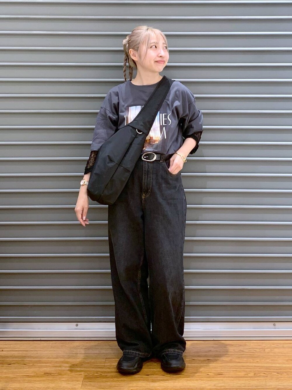 ブラック系のデニムパンツ、ブラック系のスニーカー、ブラック系のショルダーバッグを着用したレディースの秋コーディネートの5枚目の写真