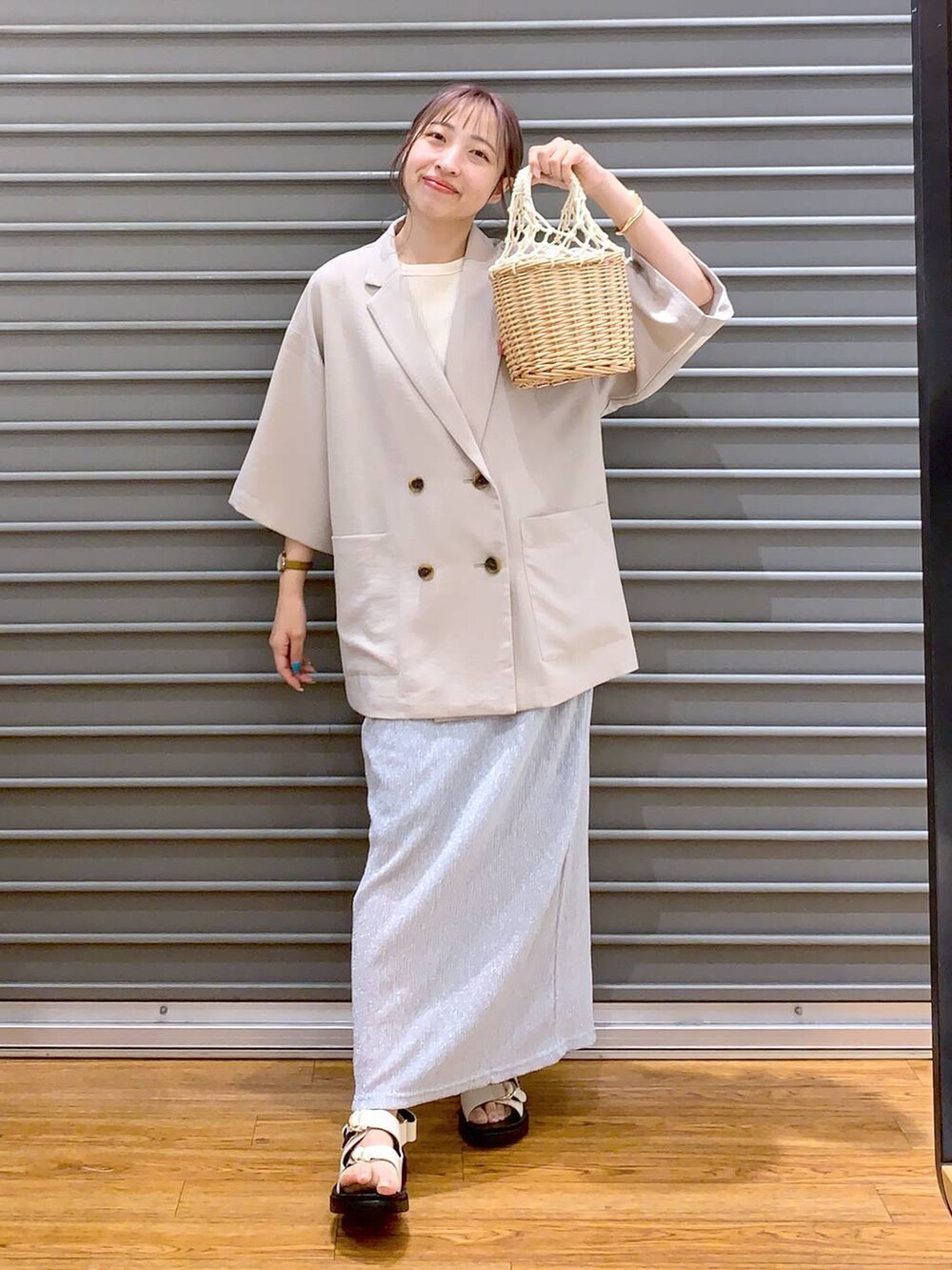 ベージュ系のテーラードジャケット、ホワイト系のサンダル、グレー系のスカートを着用したレディースの夏コーディネートの4枚目の写真