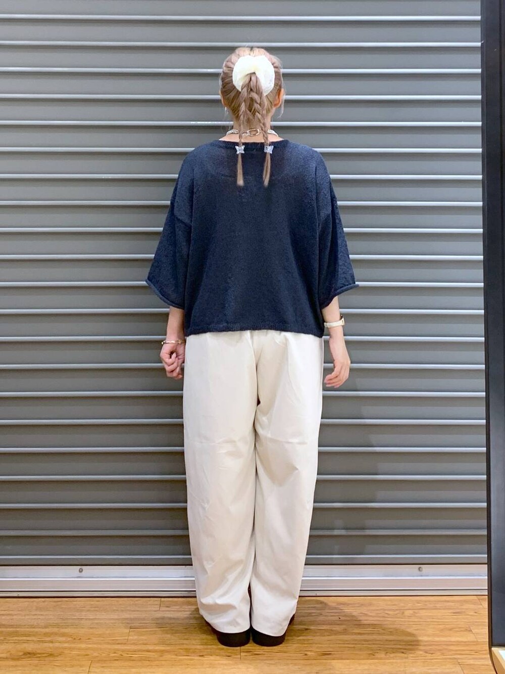 ホワイト系のその他パンツ、ブラック系のショルダーバッグ、ブルー系のニット/セーターを着用したレディースの夏コーディネートの2枚目の写真