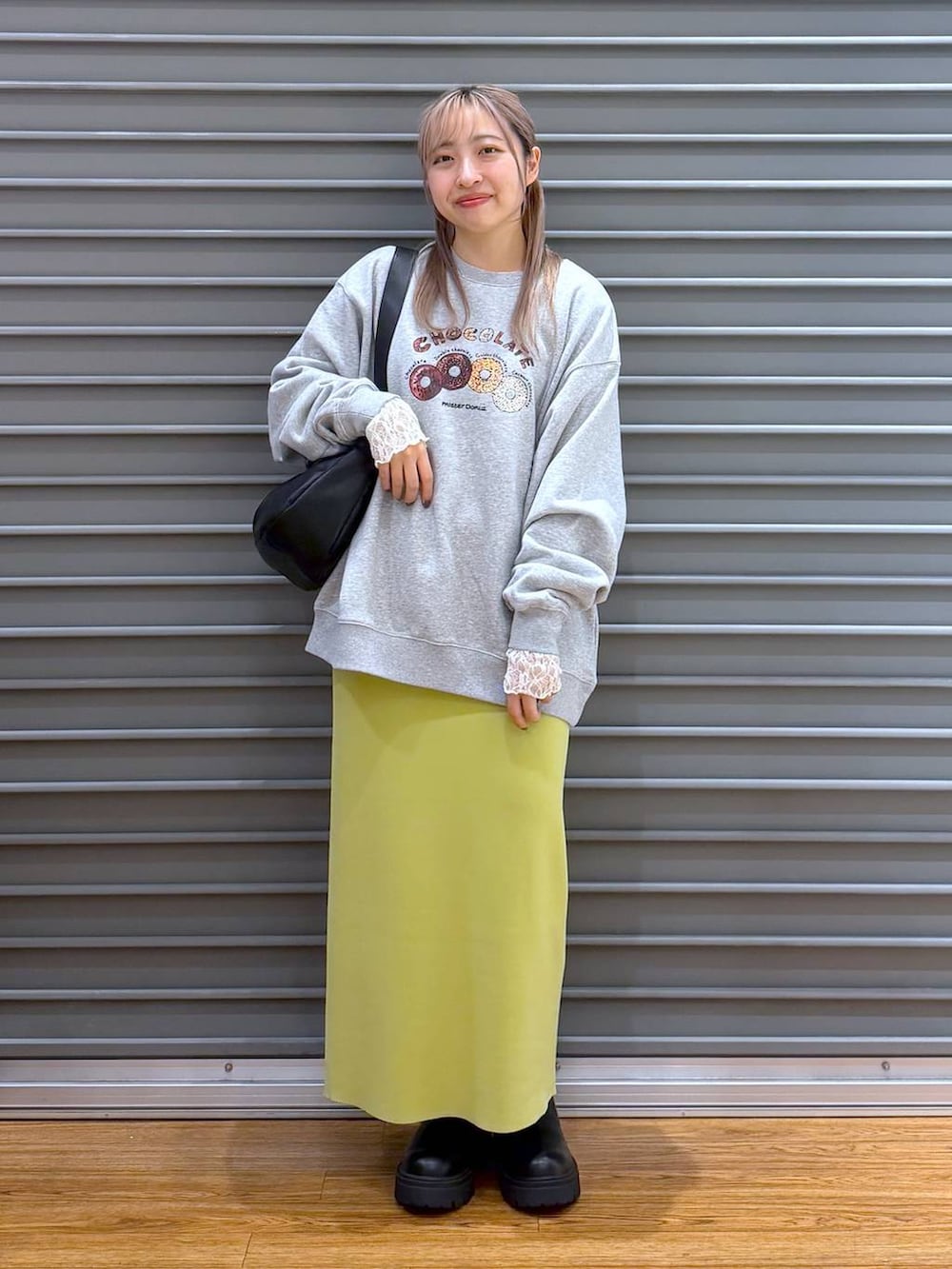 グリーン系のスカート、ブラック系のブーツ、グレー系のスウェットを着用したレディースの冬コーディネートの5枚目の写真