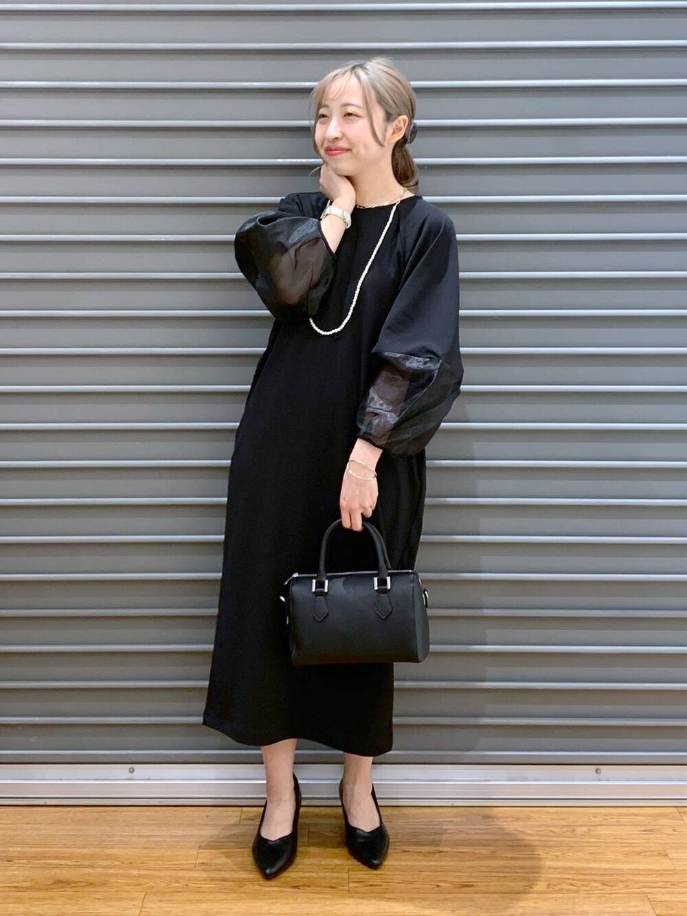 ブラック系のワンピース、ブラック系のパンプス、ブラック系のボストンバッグを着用したレディースの冬コーディネートの5枚目の写真