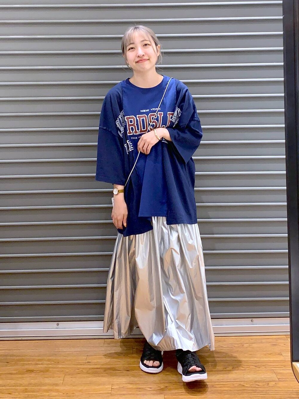 ブラック系のサンダル、シルバー系のスカート、ブルー系のTシャツ/カットソーを着用したレディースの春コーディネートの3枚目の写真