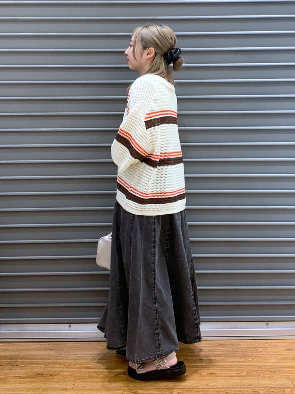 ベージュ系のサンダル、グレー系のスカート、ホワイト系のショルダーバッグを着用したレディースの春コーディネートの3枚目の写真