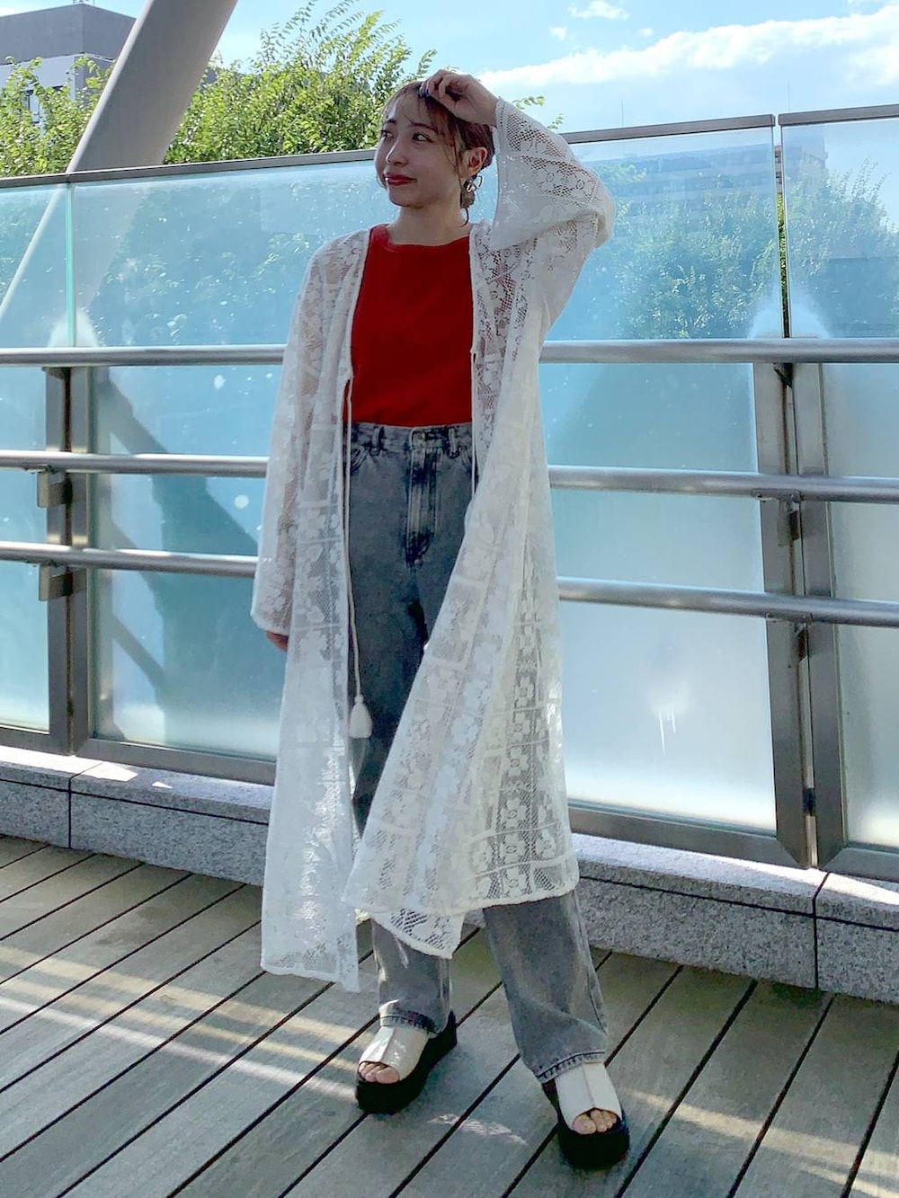 ホワイト系のワンピース、ホワイト系のサンダル、オレンジ系のタンクトップを着用したレディースの夏コーディネートの2枚目の写真