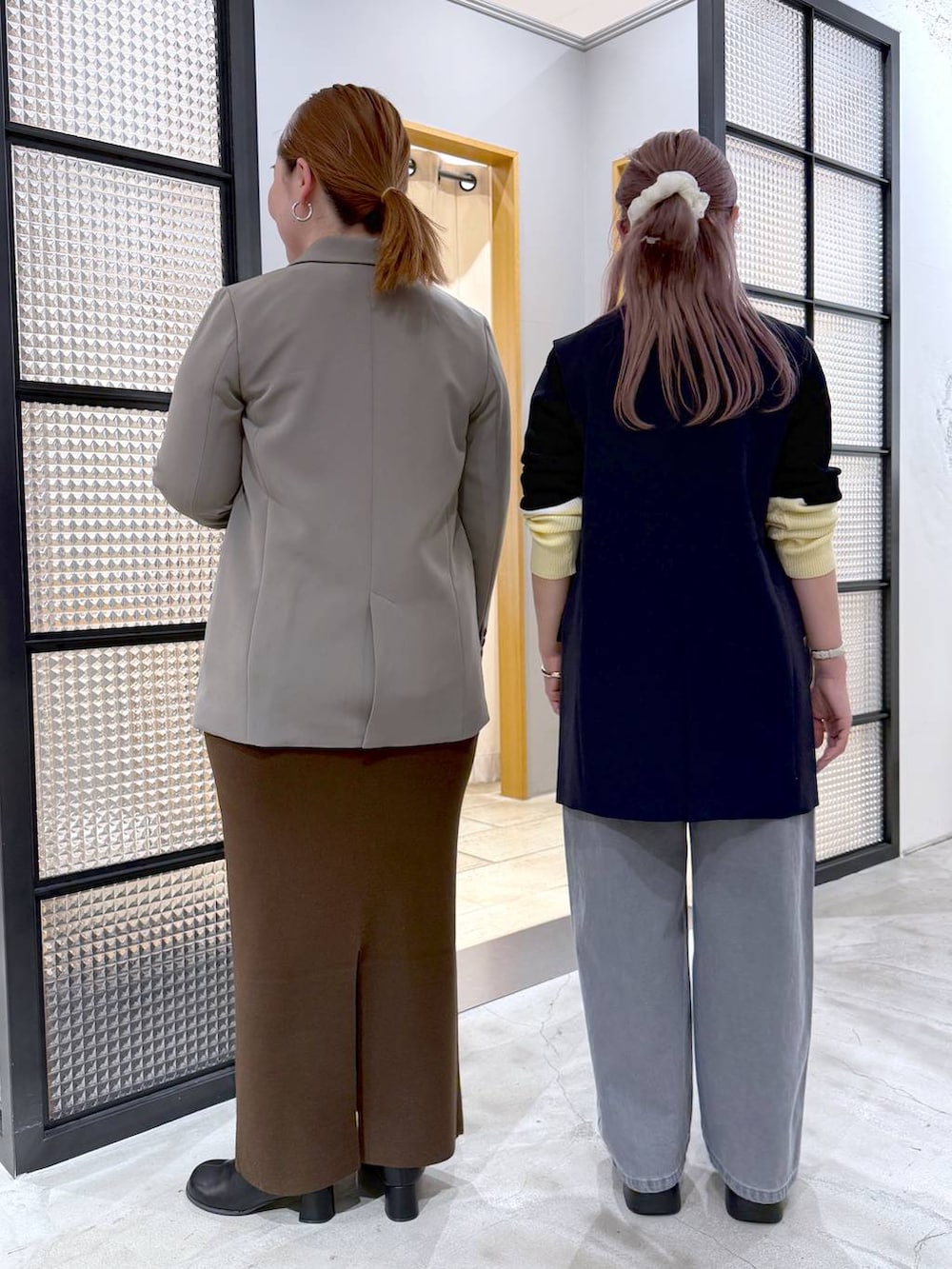 ブラウン系のスカート、ブラック系のニット/セーター、ブラック系のブーツを着用したレディースの冬コーディネートの2枚目の写真