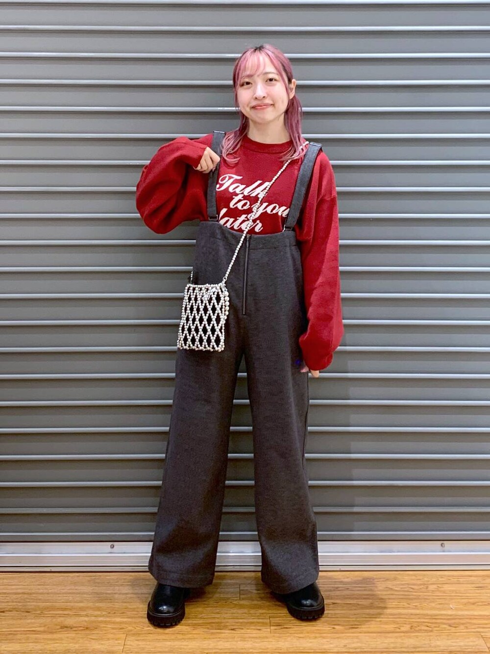 シルバー系のショルダーバッグ、レッド系のニット/セーター、ブラック系のブーツを着用したレディースの冬コーディネートの4枚目の写真