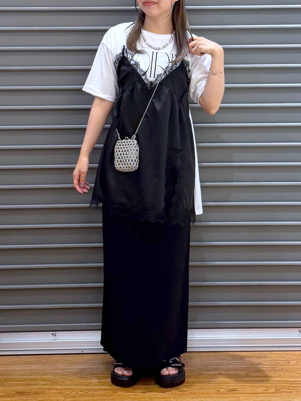 ブラック系のスカート、ブラック系のサンダル、ホワイト系のTシャツ/カットソーを着用したレディースの夏コーディネートの4枚目の写真