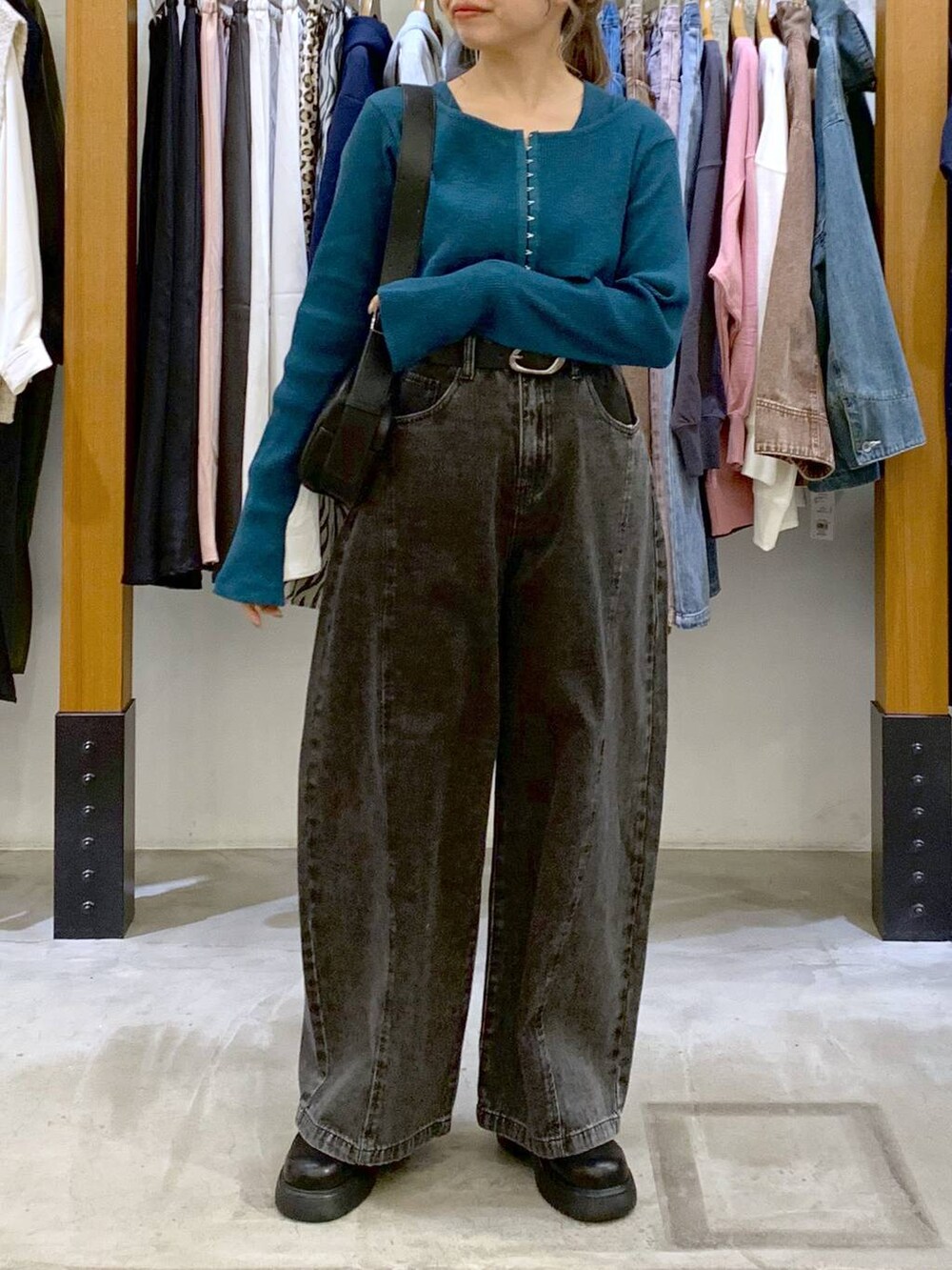 グリーン系のTシャツ/カットソー、ブラック系のデニムパンツ、ブラック系のショルダーバッグを着用したレディースの春コーディネートの4枚目の写真