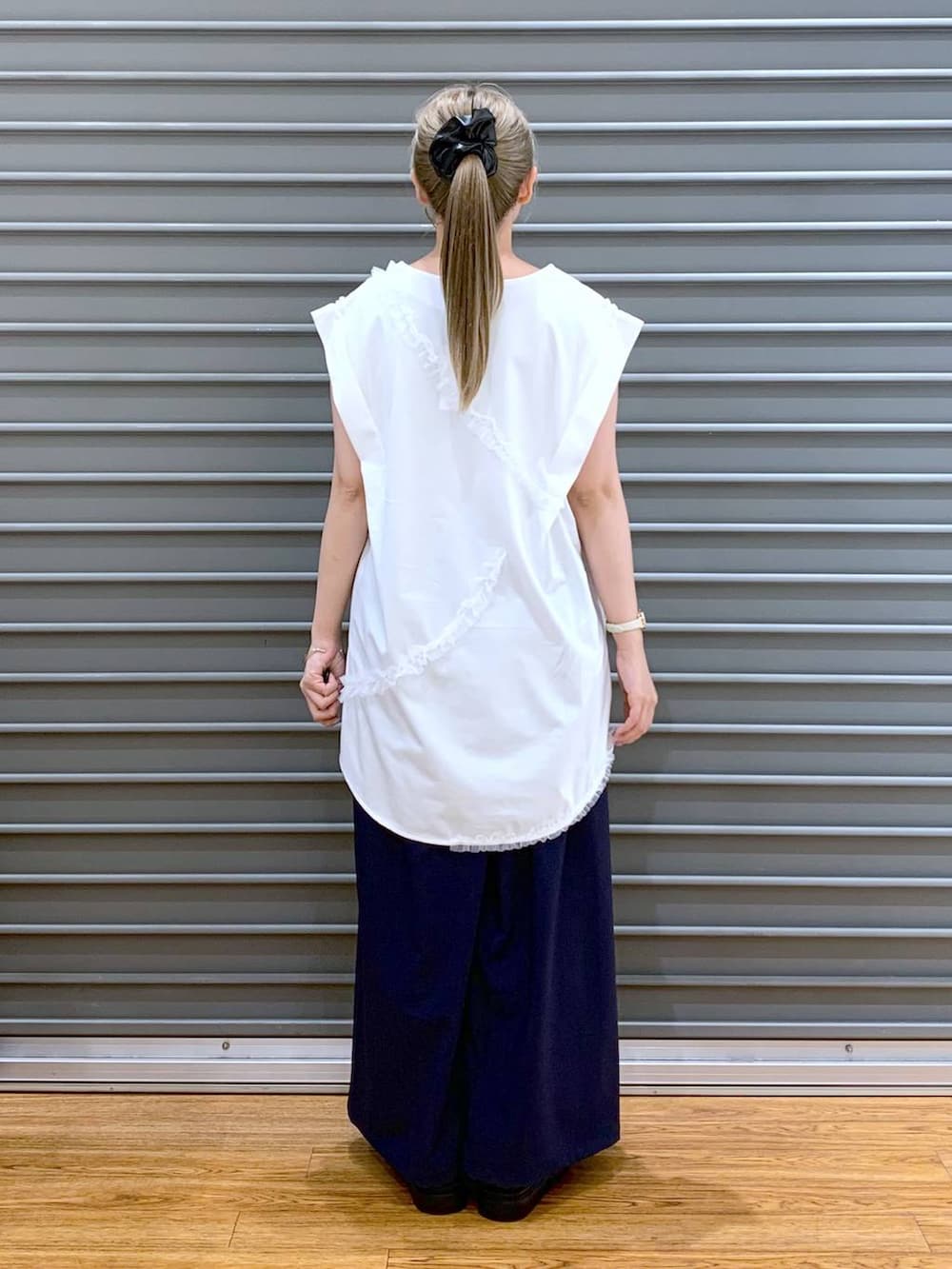 ブラック系のサンダル、ブルー系のその他パンツ、ホワイト系のショルダーバッグを着用したレディースの夏コーディネートの2枚目の写真