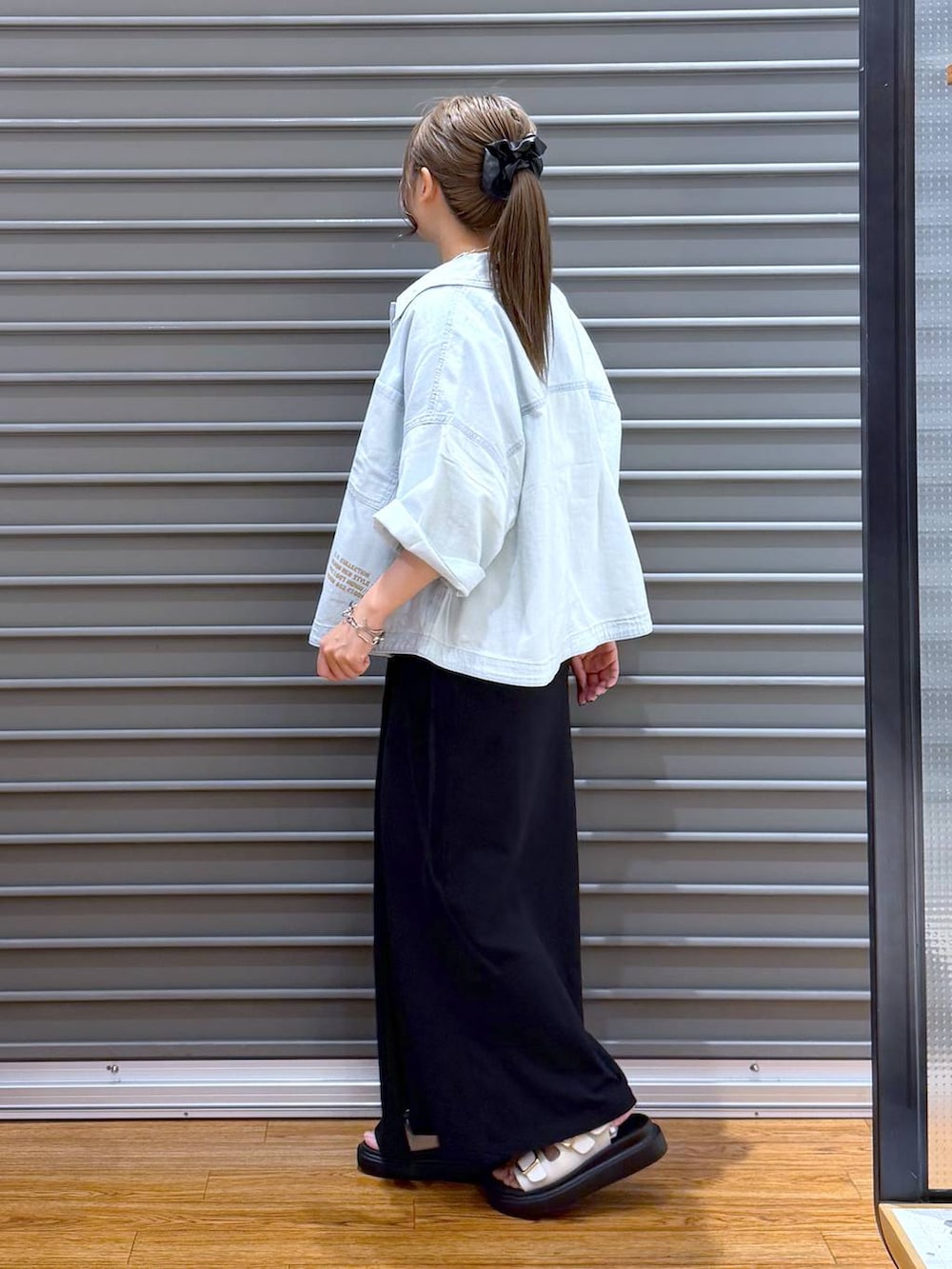 ブラック系のスカート、ホワイト系のTシャツ/カットソー、ブラック系のトートバッグを着用したレディースの夏コーディネートの3枚目の写真