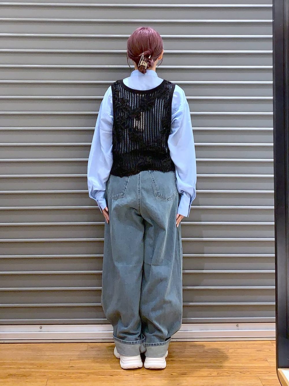 ホワイト系のショルダーバッグ、ブルー系のデニムパンツ、ホワイト系のスニーカーを着用したレディースの秋コーディネートの2枚目の写真