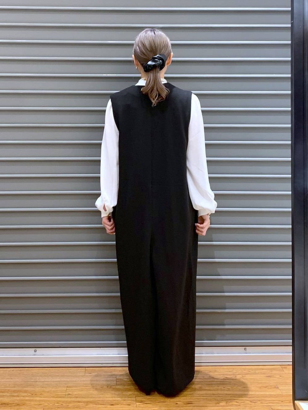 ホワイト系のシャツ/ブラウス、ブラック系のサロペット/オーバーオール、ブラック系のパンプスを着用したレディースの冬コーディネートの2枚目の写真