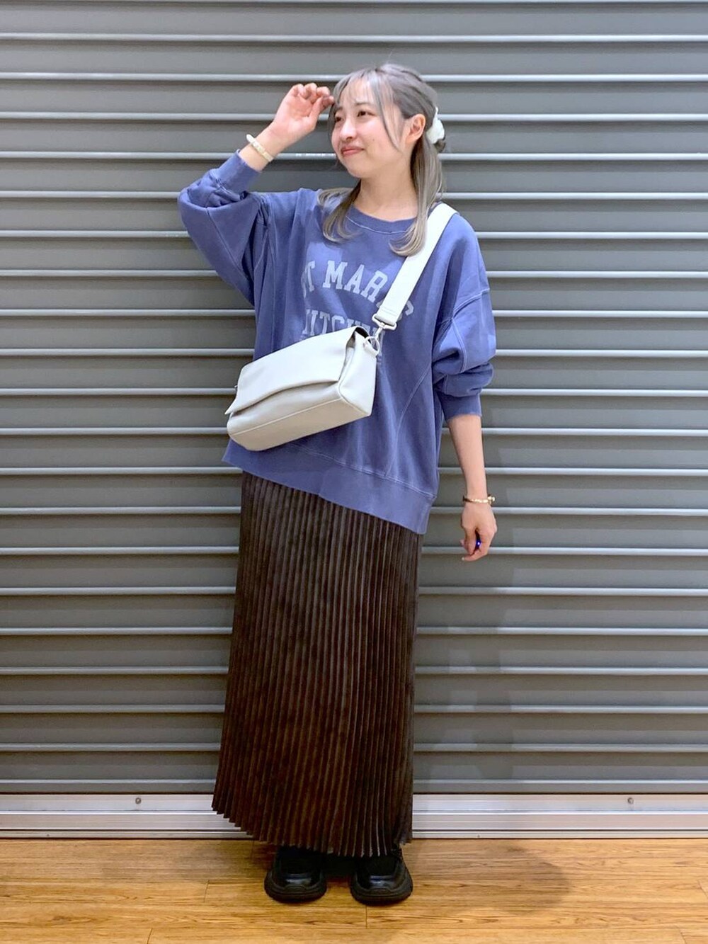 グレー系のショルダーバッグ、ブラック系のスニーカー、グレー系のスカートを着用したレディースの秋コーディネートの4枚目の写真