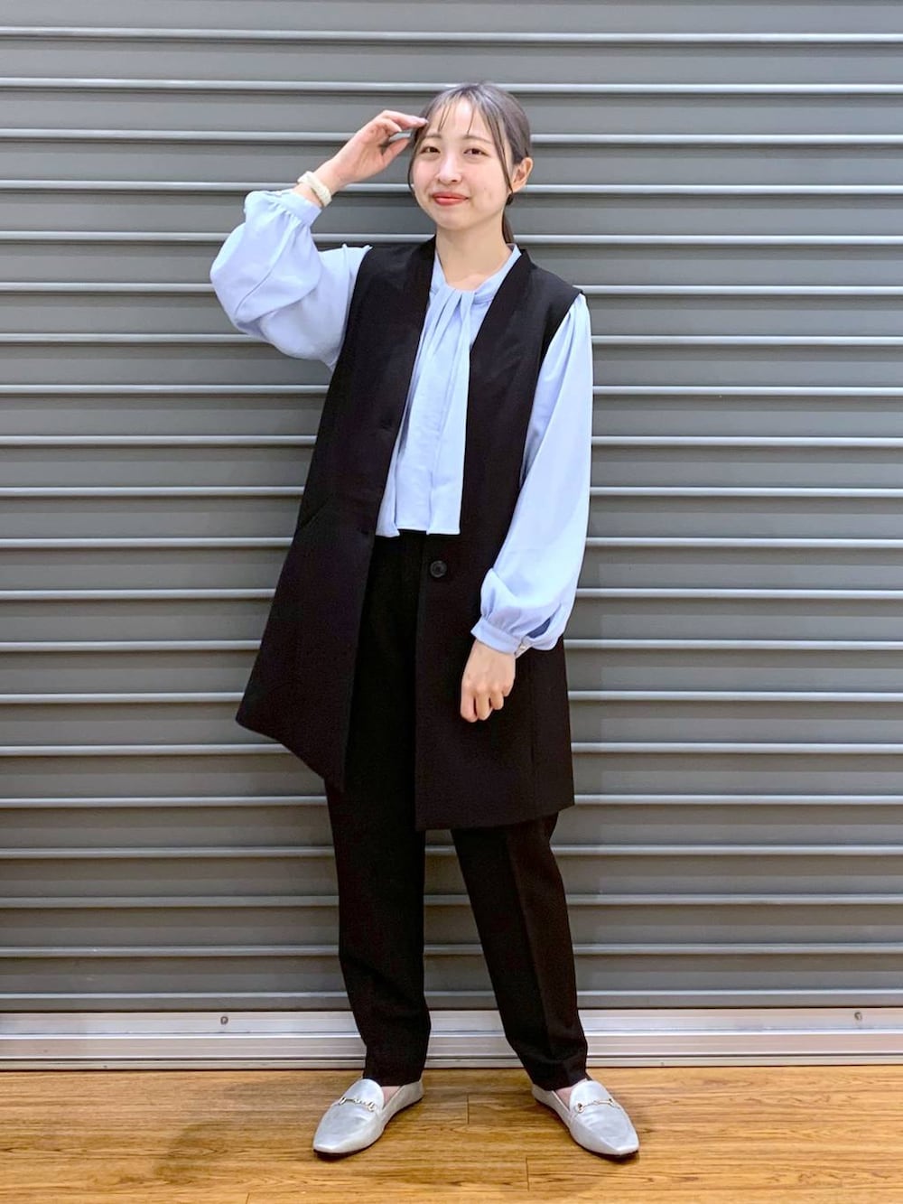 ブラック系のスーツパンツ、ブルー系のシャツ/ブラウス、ブラック系のスーツベストを着用したレディースの冬コーディネートの5枚目の写真