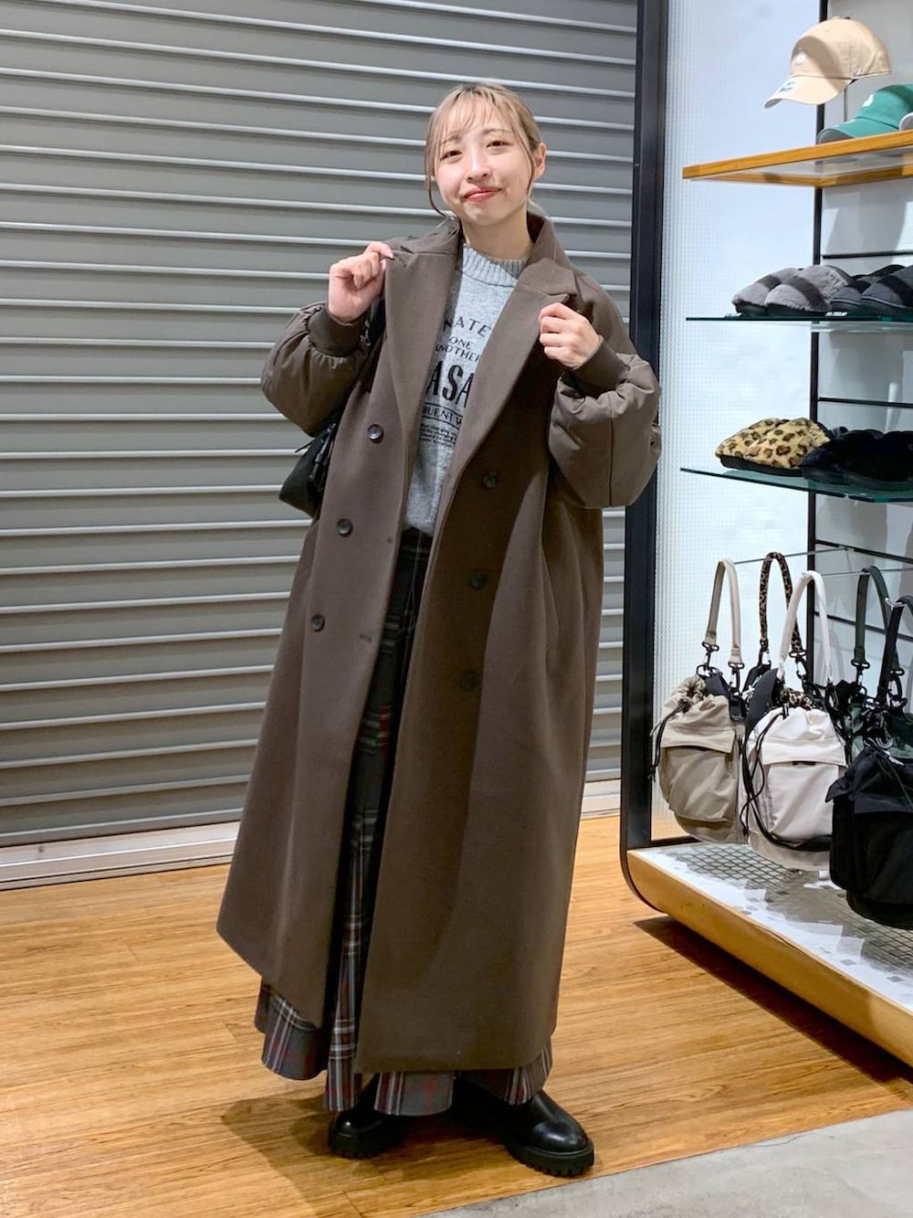 ブラック系のブーツ、グレー系のスカート、ブラック系のショルダーバッグを着用したレディースの冬コーディネートの5枚目の写真