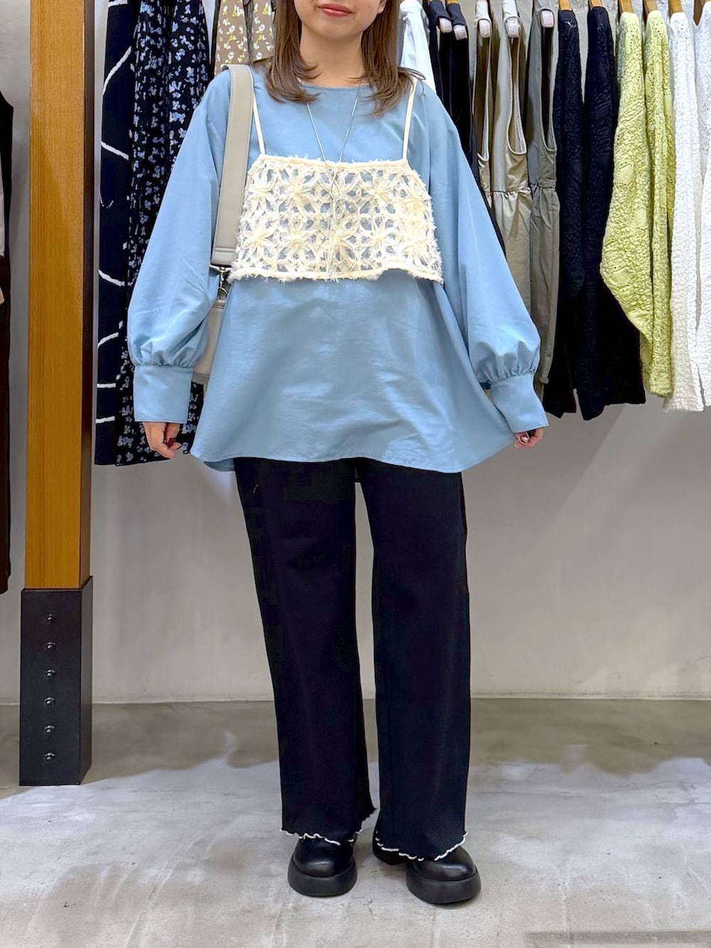 グレー系のショルダーバッグ、ブラック系のサンダル、ブルー系のシャツ/ブラウスを着用したレディースの冬コーディネートの4枚目の写真