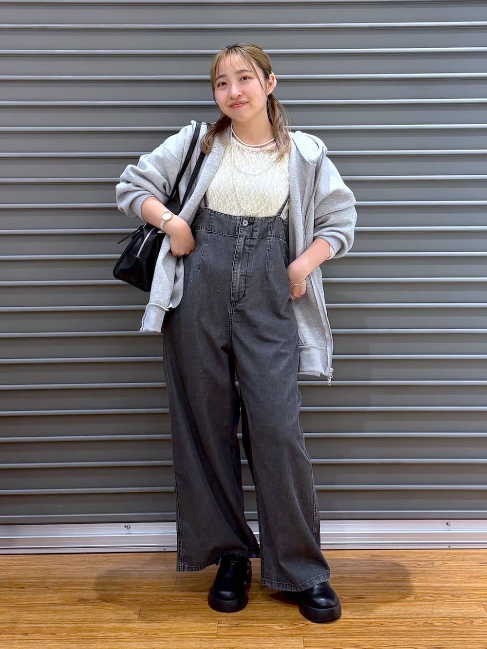 ブラック系のサンダル、ブラック系のボストンバッグ、グレー系のパーカーを着用したレディースの春コーディネートの4枚目の写真