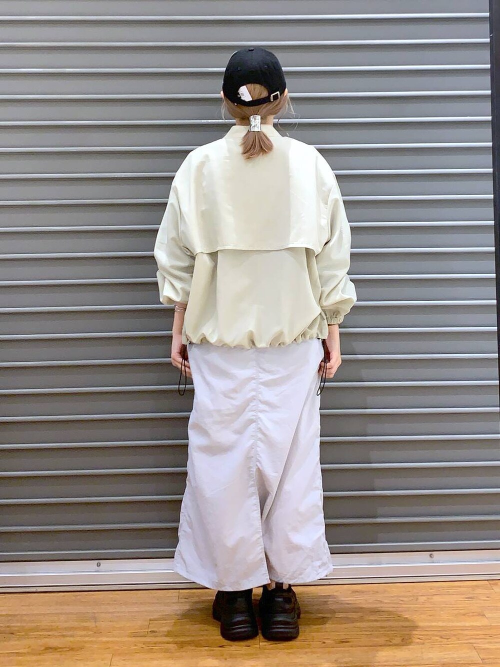 ブラック系のスニーカー、グレー系のTシャツ/カットソー、グレー系のスカートを着用したレディースの春コーディネートの2枚目の写真