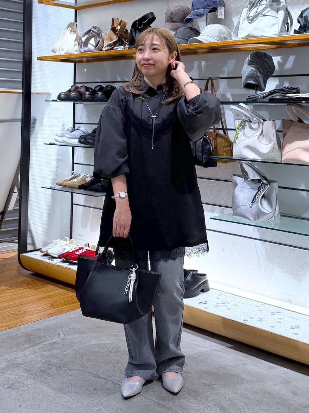 シルバー系のパンプス、グレー系のシャツ/ブラウス、ブラック系のトートバッグを着用したレディースの春コーディネートの6枚目の写真