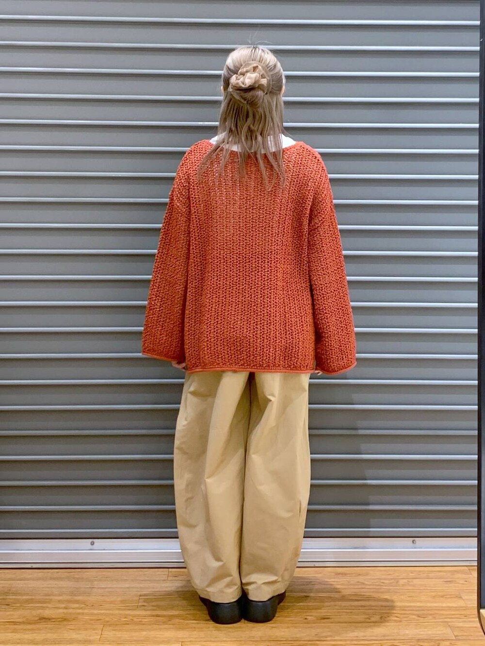 レッド系のニット/セーター、ホワイト系のショルダーバッグ、ブラック系のサンダルを着用したレディースの春コーディネートの2枚目の写真
