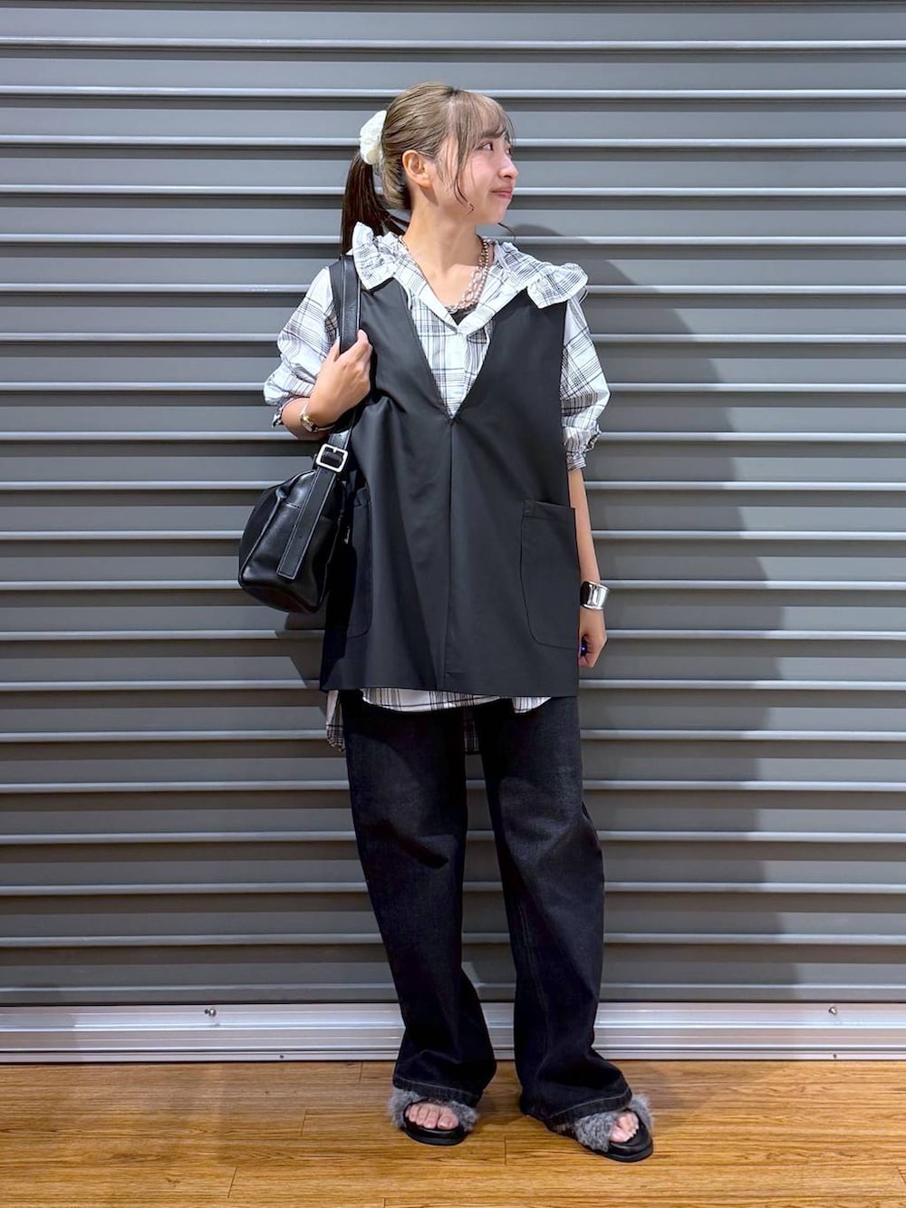 ブラック系のベスト、グレー系のサンダル、ブラック系のデニムパンツを着用したレディースの夏コーディネートの4枚目の写真