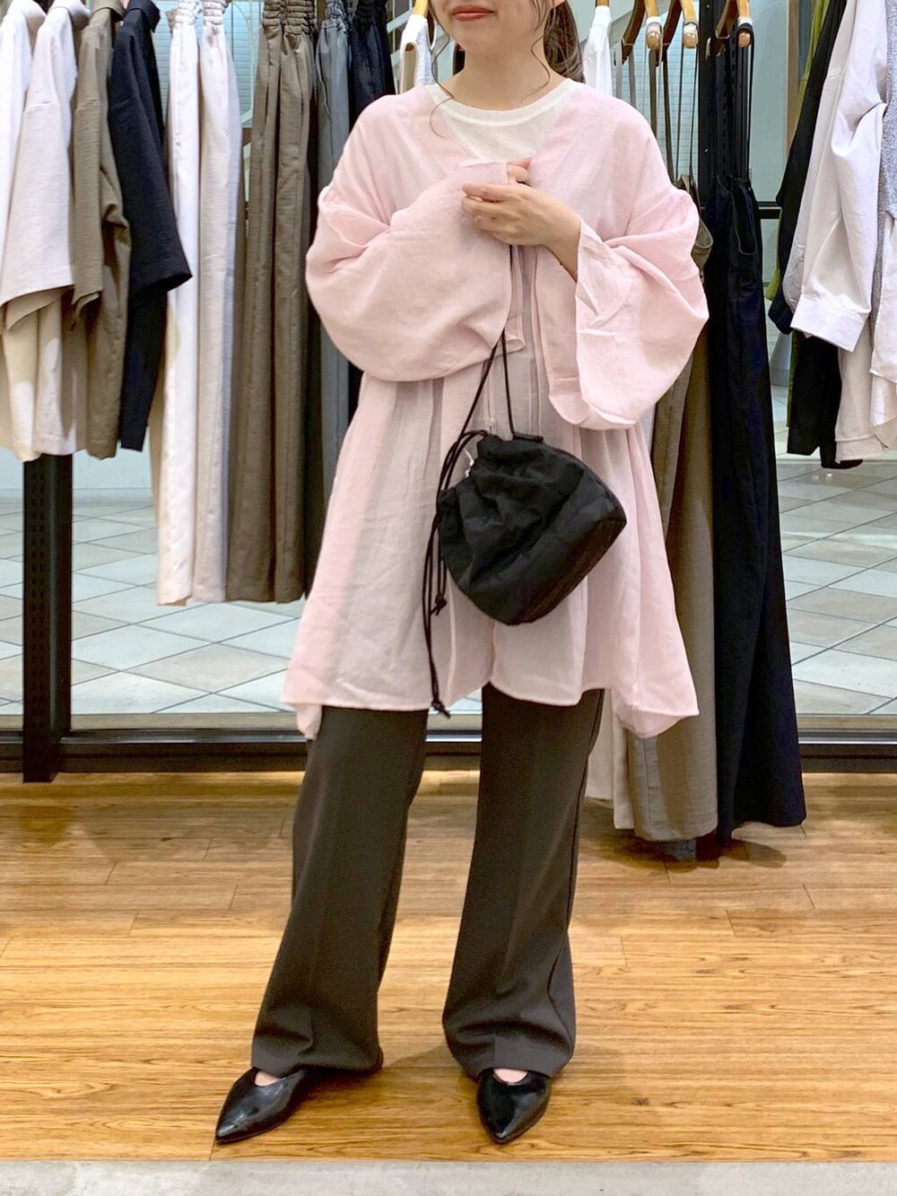 ホワイト系のTシャツ/カットソー、グレー系のスラックス、ブラック系のショルダーバッグを着用したレディースの春コーディネートの5枚目の写真