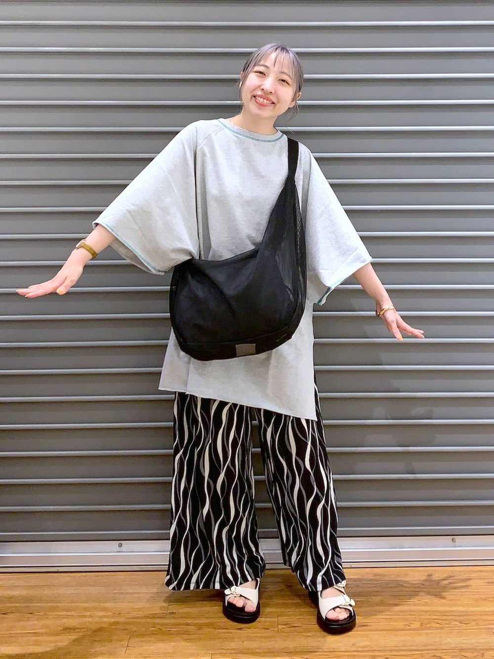 ブラック系のショルダーバッグ、グレー系のTシャツ/カットソー、ブラック系のその他パンツを着用したレディースの春コーディネートの4枚目の写真