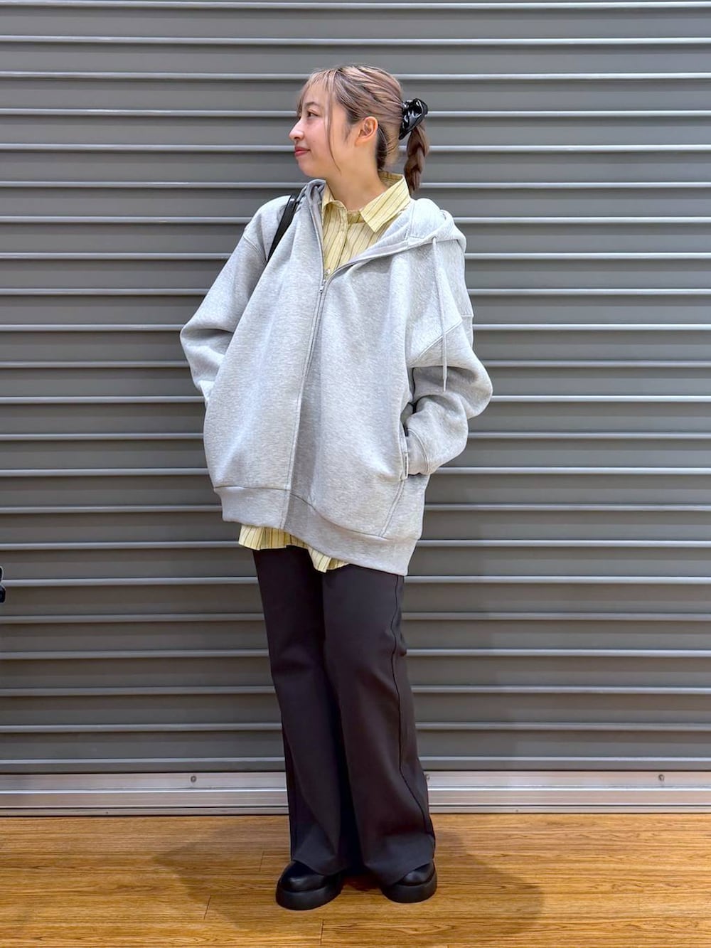 ブラック系のサンダル、ブラック系のボストンバッグ、グレー系のパーカーを着用したレディースの冬コーディネートの6枚目の写真