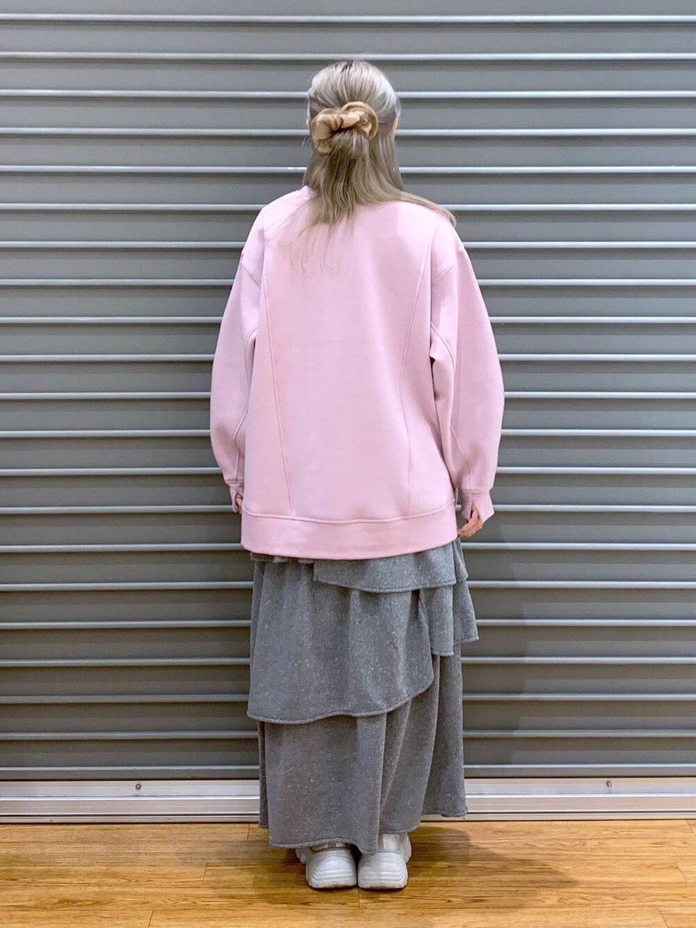 ブラック系のショルダーバッグ、ピンク系のスウェット、シルバー系のスニーカーを着用したレディースの秋コーディネートの2枚目の写真