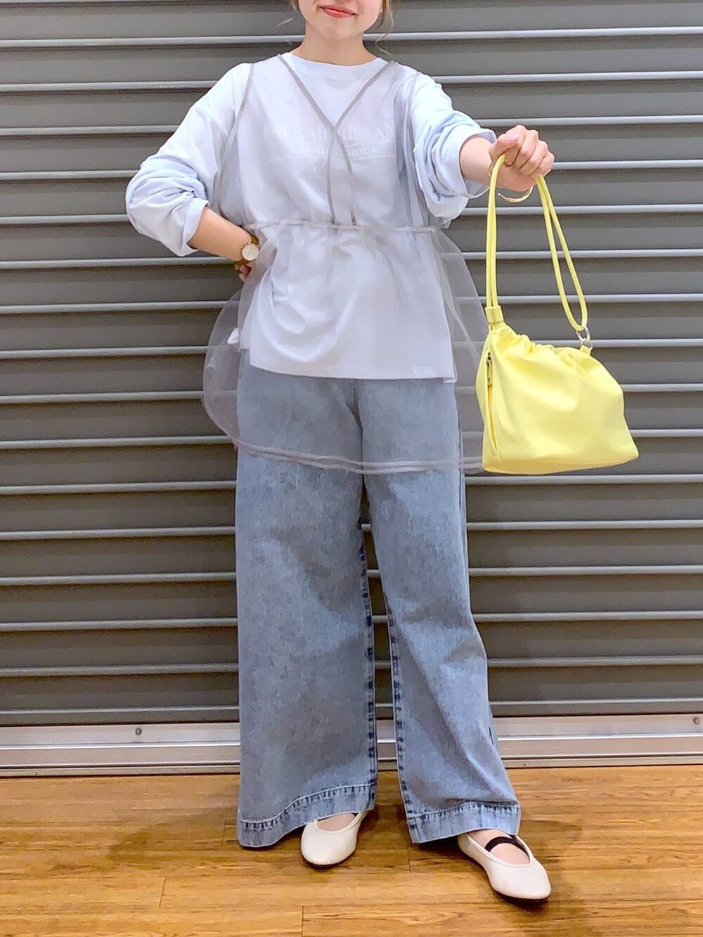 ブルー系のデニムパンツ、ホワイト系のバレエシューズ、イエロー系のショルダーバッグを着用したレディースの春コーディネートの8枚目の写真