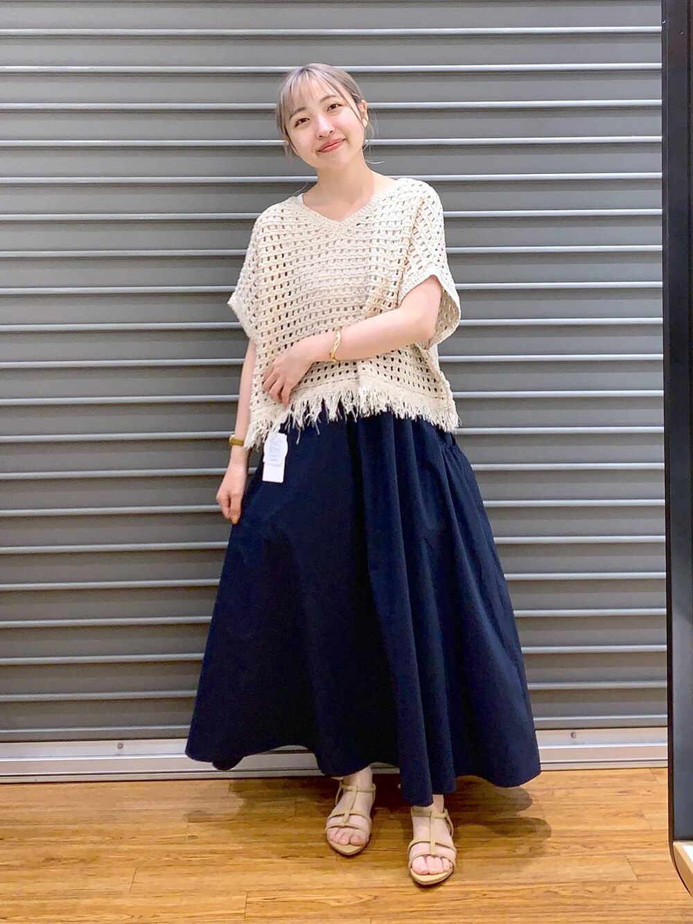 ベージュ系のサンダル、ブラウン系のショルダーバッグ、ブルー系のスカートを着用したレディースの春コーディネートの4枚目の写真