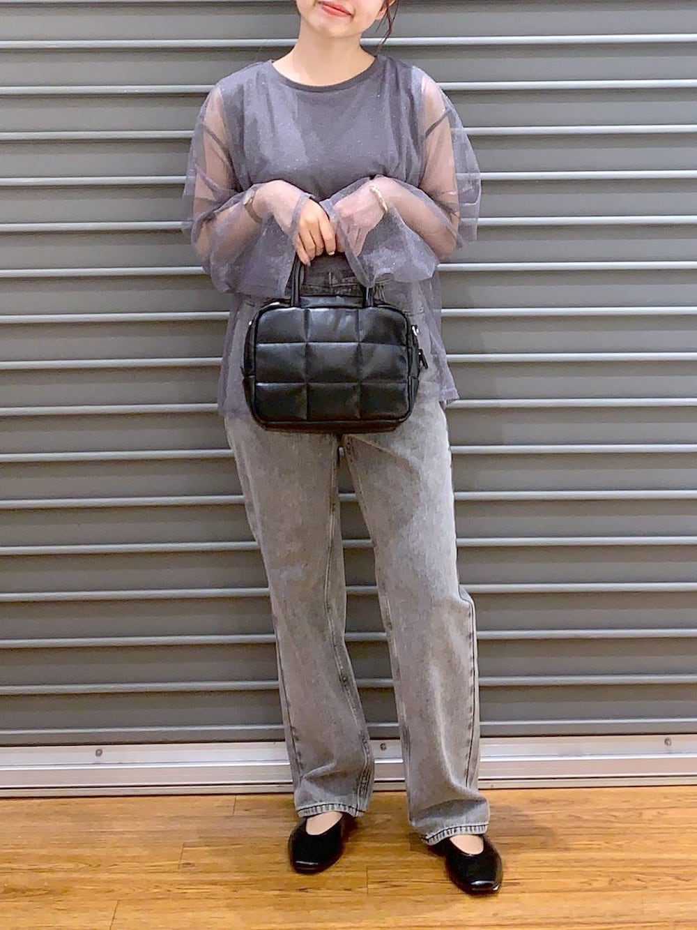 グレー系のデニムパンツ、ブラック系のパンプス、ブラック系のボストンバッグを着用したレディースの秋コーディネートの4枚目の写真
