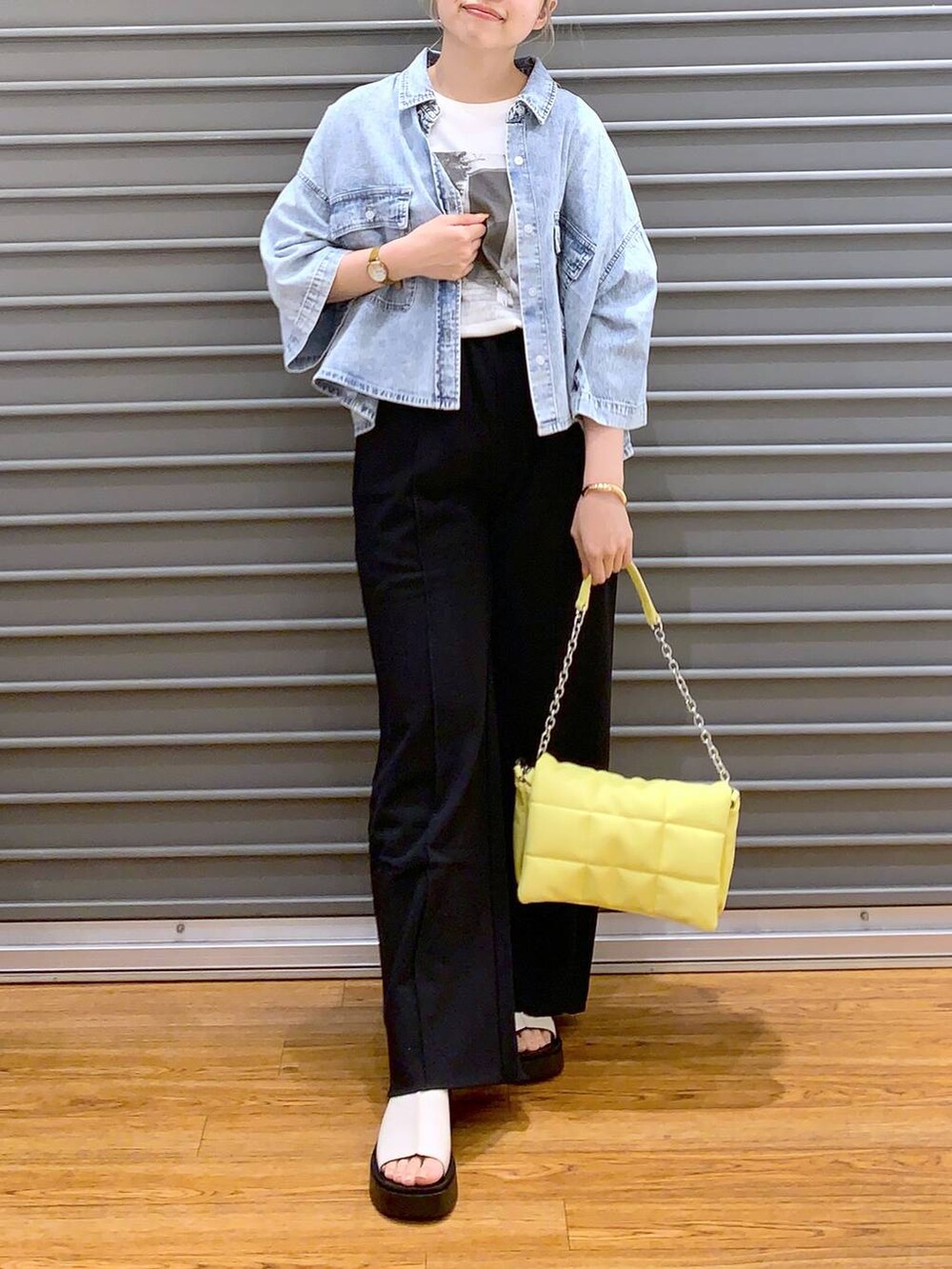 イエロー系のショルダーバッグ、ブルー系のシャツ/ブラウス、ホワイト系のサンダルを着用したレディースの春コーディネートの3枚目の写真