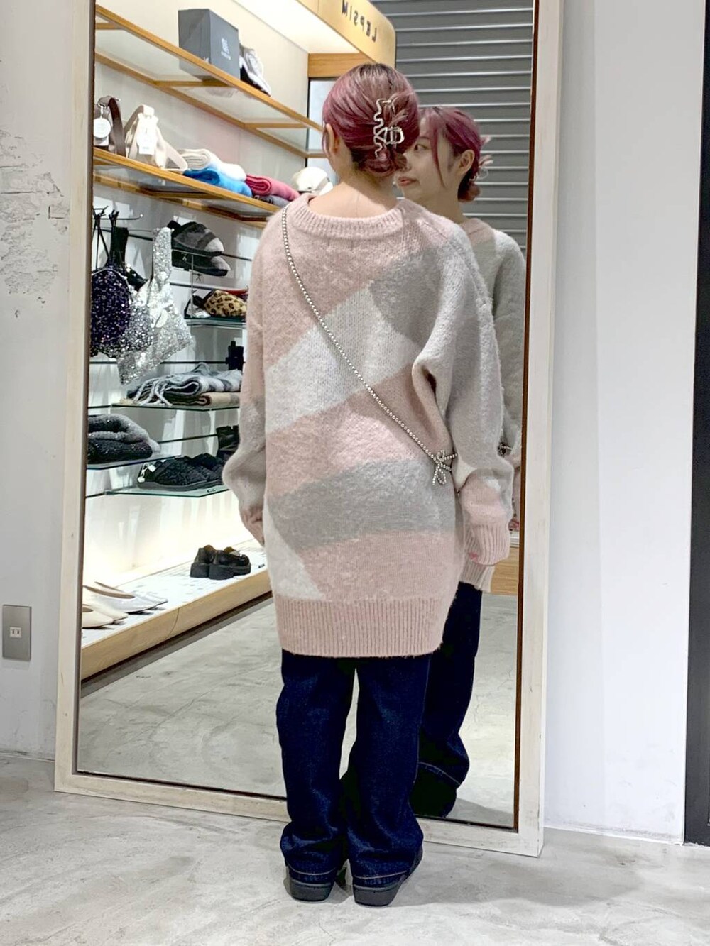 ブルー系のデニムパンツ、ブラック系のその他シューズ、ピンク系のチュニックを着用したレディースの秋コーディネートの2枚目の写真