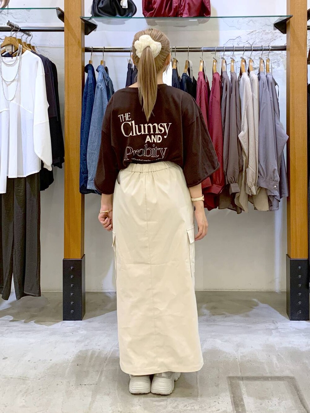 ホワイト系のスカート、ブラウン系のショルダーバッグ、ブラウン系のTシャツ/カットソーを着用したレディースの秋コーディネートの2枚目の写真