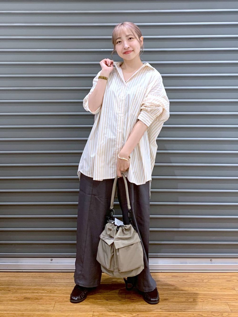 ベージュ系のショルダーバッグ、ブラウン系のローファー、グレー系のその他パンツを着用したレディースの秋コーディネートの4枚目の写真