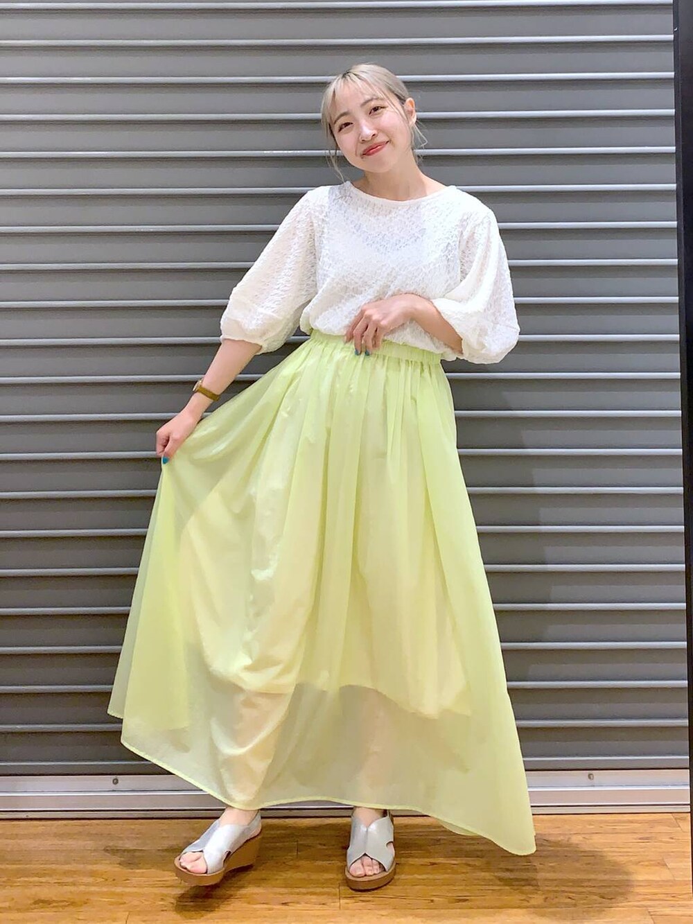 ホワイト系のTシャツ/カットソー、シルバー系のサンダル、イエロー系のスカートを着用したレディースの夏コーディネートの3枚目の写真